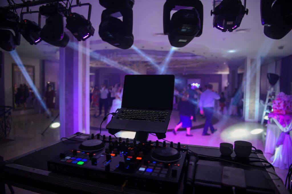 DJ setup with computer and lights at a wedding.