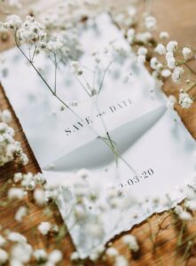 Save the date card with baby's breath on it and around it.